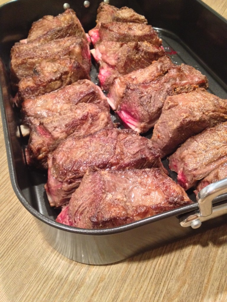 After all the short ribs were browned, I braised them in the oven for 2 1/2 hours.  Cooled them in the braising liquid overnight.  All the client had to do was heat in the oven for 30 minutes and then serve!